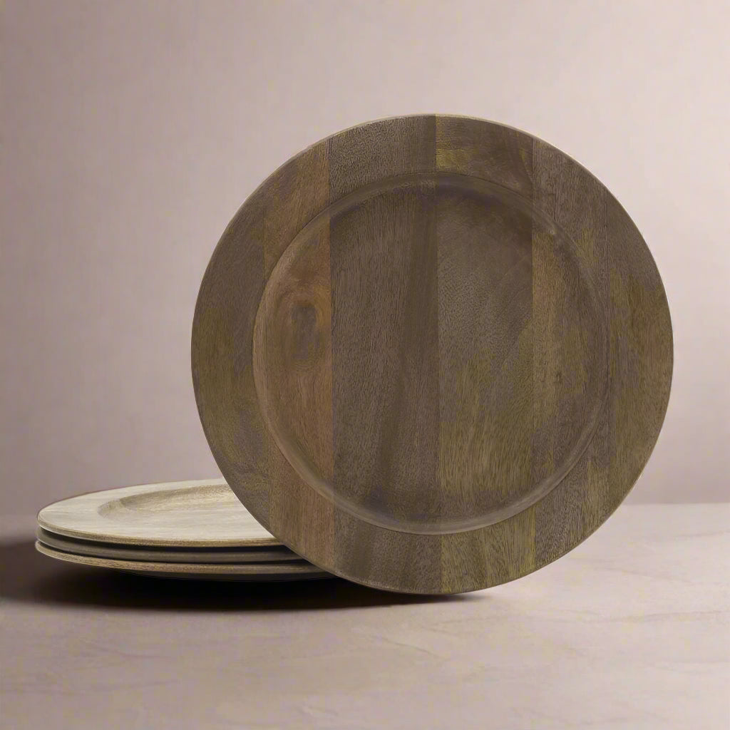 Set of four round mango wood charger plates in natural brown tones