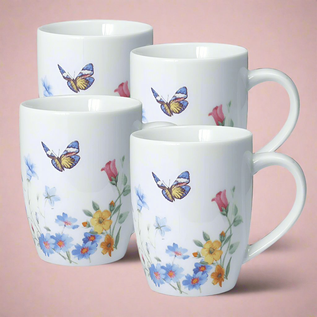 Set of four white mugs with butterfly and floral pattern against a pink background.