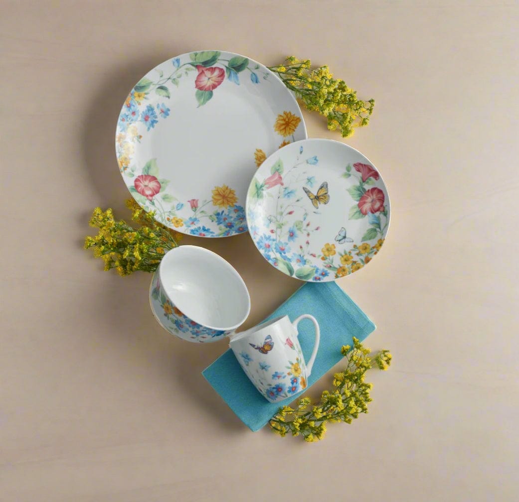 Annabelle floral set of four salad plates paired with a matching mug and bowl on a beige background with yellow flowers.