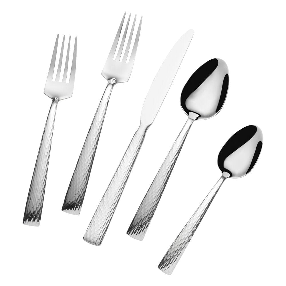Hammered stainless steel flatware pieces including two forks a knife and two spoons on a white background.
