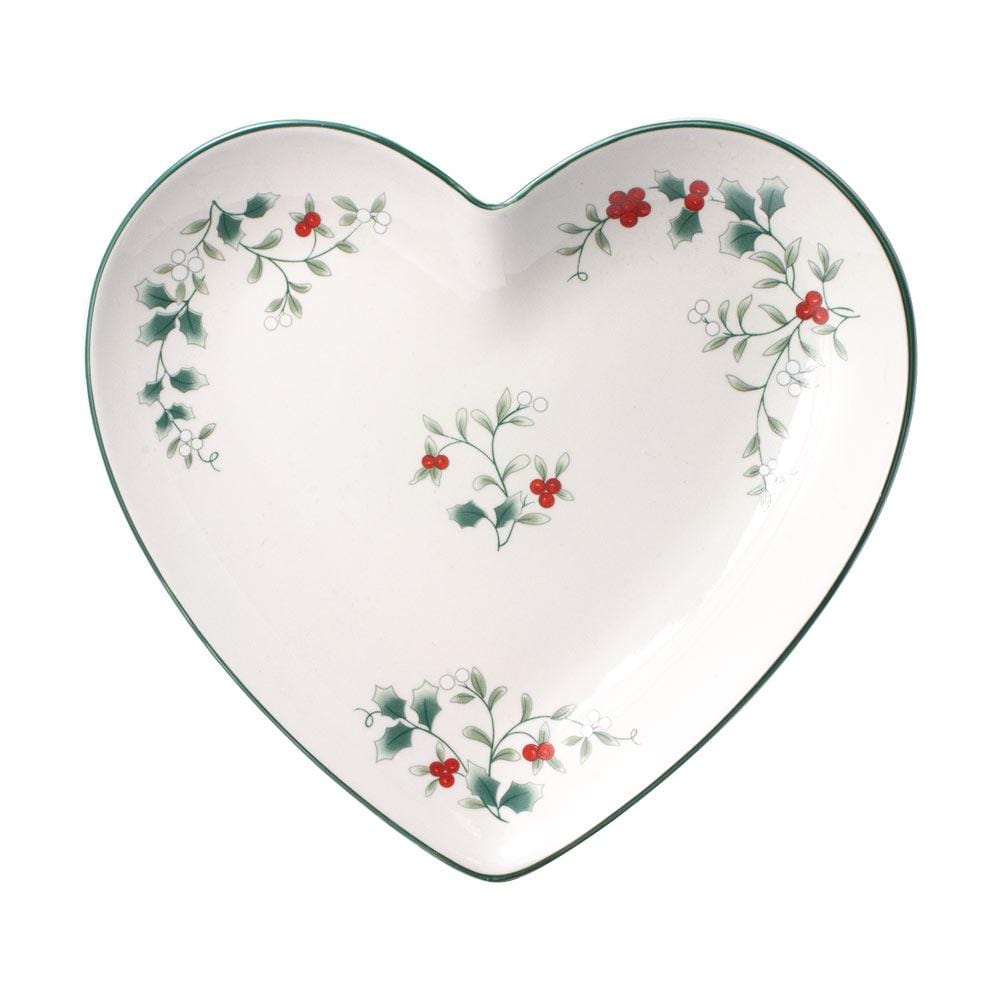 Angled view of a Winterberry heart platter featuring holly motifs and a green edge on white ceramic.