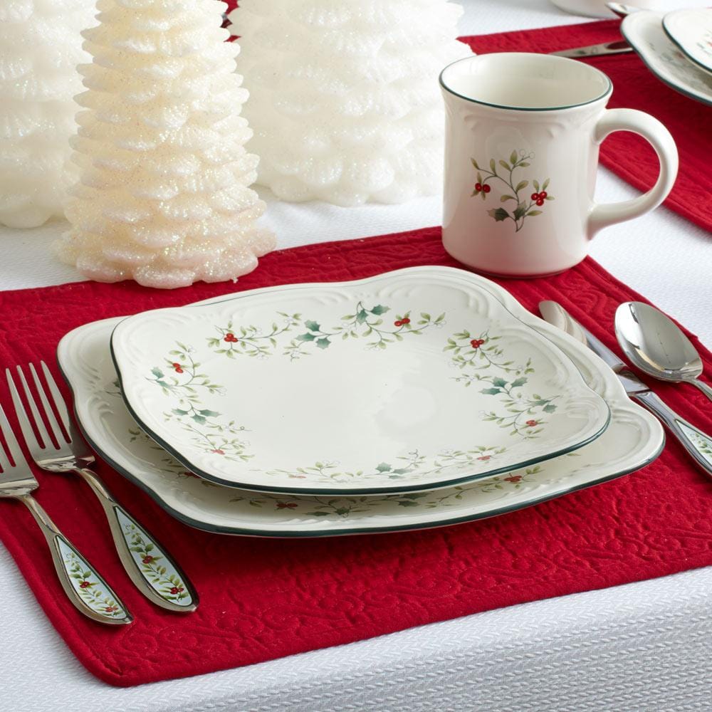 Holiday table setting with Winterberry square salad plates, a matching mug, and a red placemat.