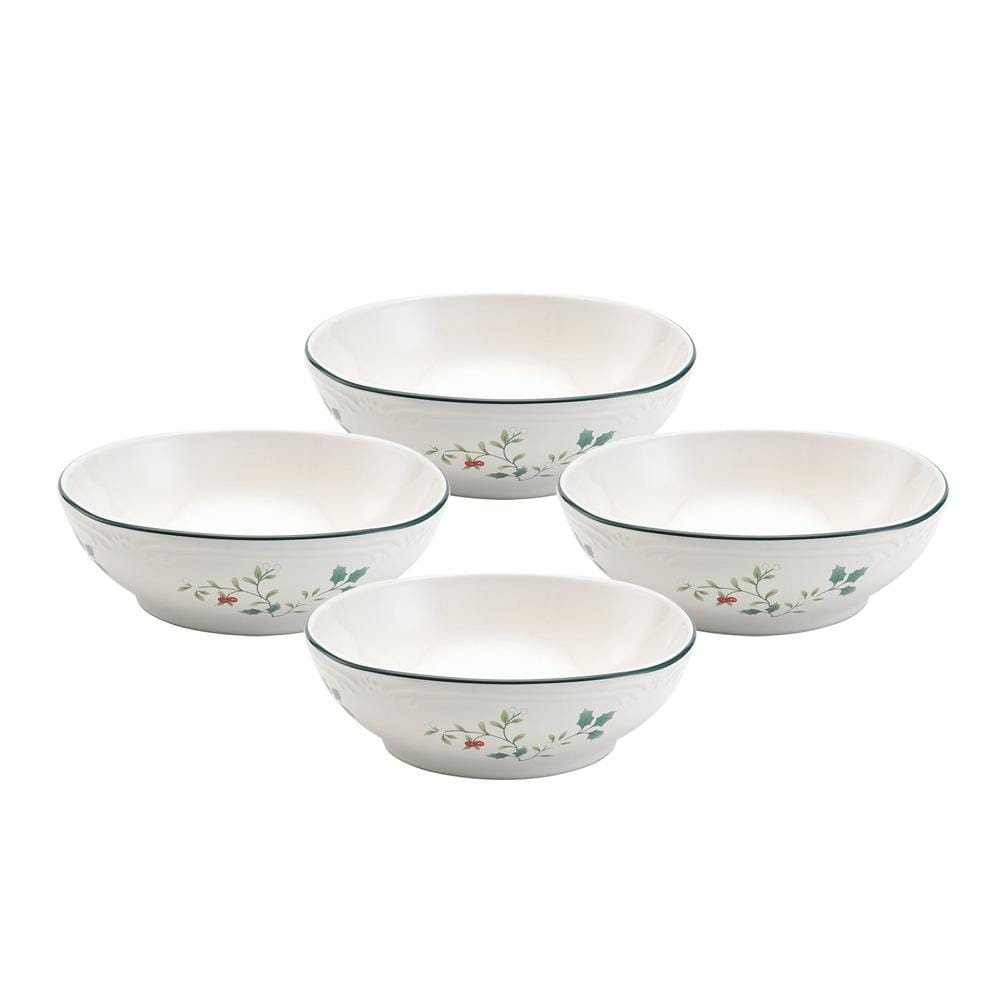 Four white Winterberry bowls with holly pattern and green rims arranged on a light wood surface