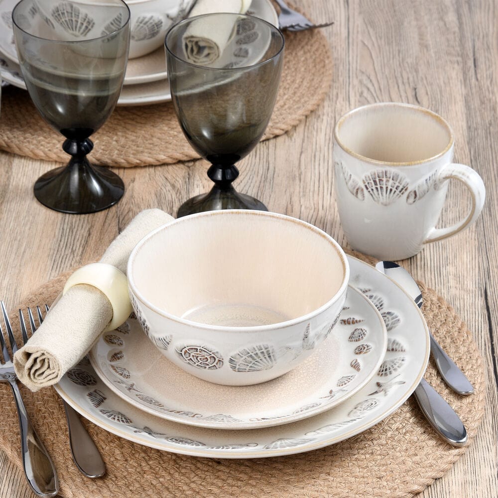 Panama dinnerware set for four arranged as a place setting with a bowl on a large plate and a mug on a woven mat.