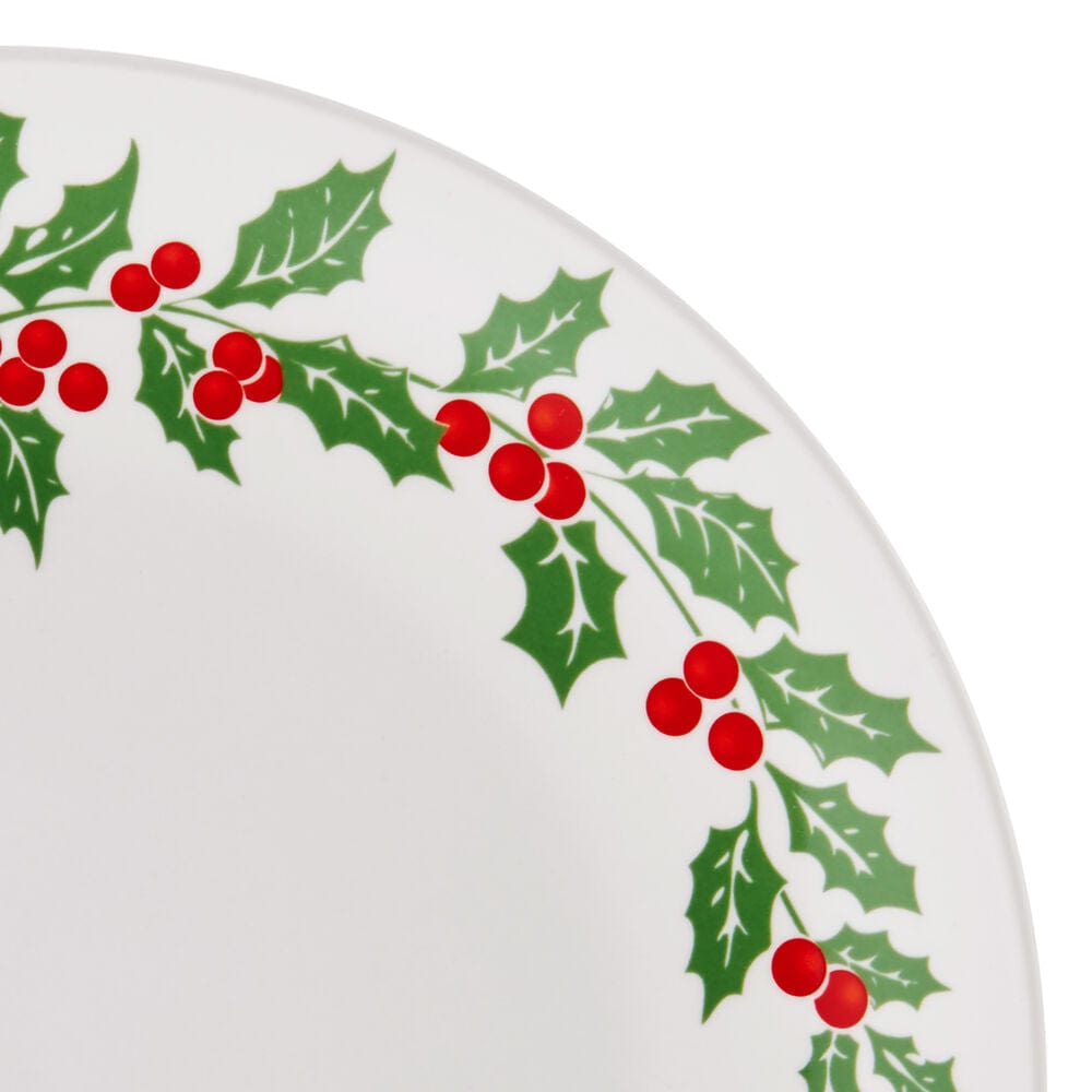 Close-up of a white plate with a green holly leaf border and red berries along the edge