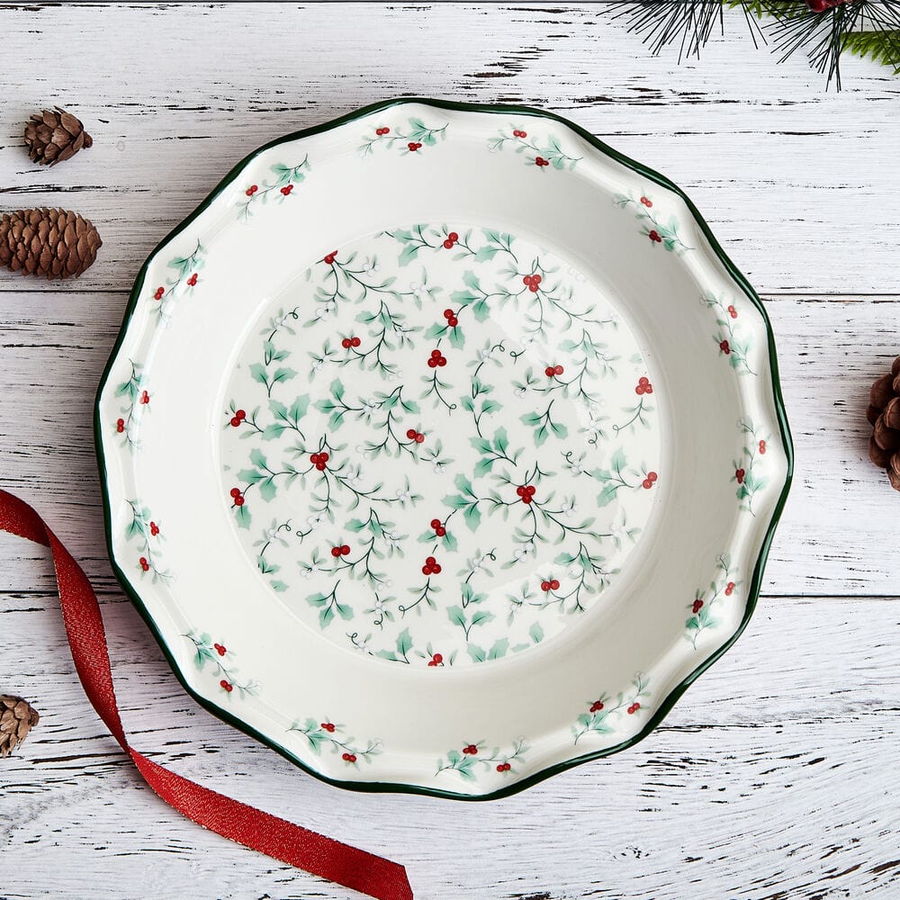 Winterberry Pie Plate on rustic white wood table with red ribbon and pinecones.