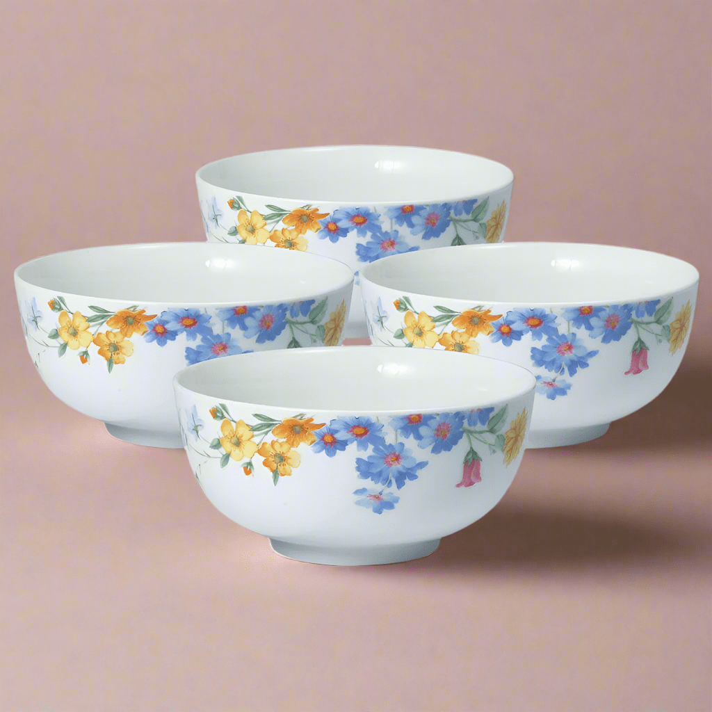 Set of four white bowls with yellow and blue flowers on a pink background
