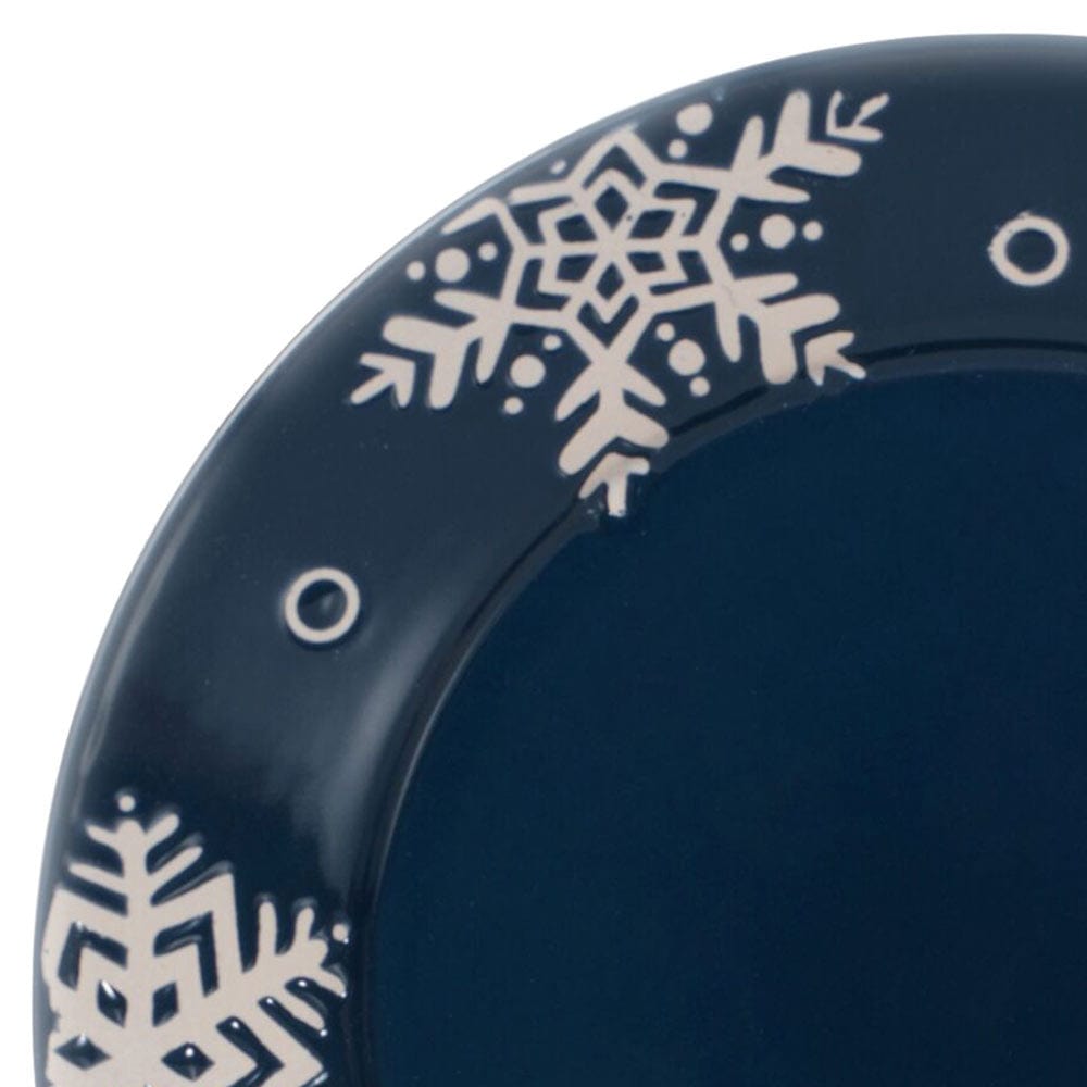Close-up of navy Snow Flurry plate rim showing intricate white snowflake design
