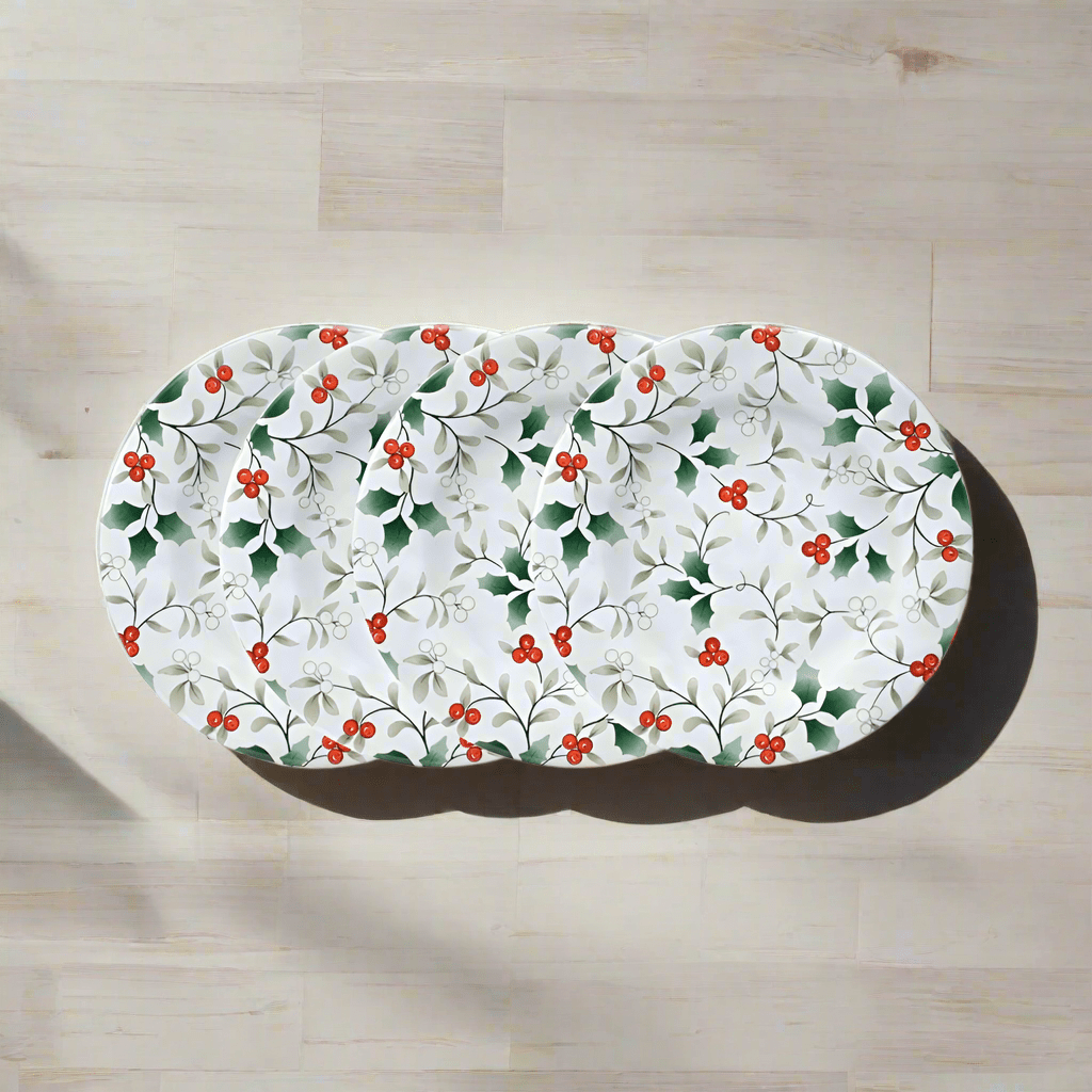 Winterberry four melamine salad plates with holly pattern arranged on a light wood surface