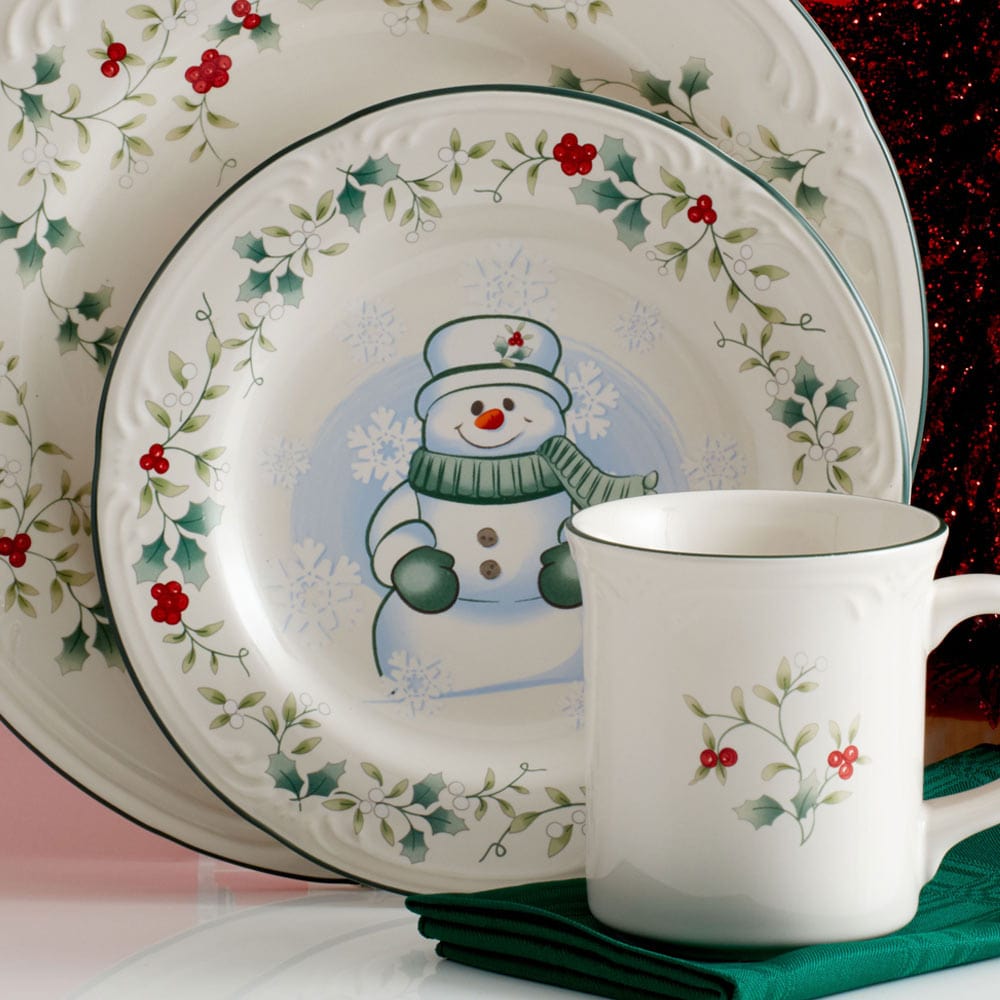 Winterberry snowman salad plate with matching mug and holly bordered plates on display.