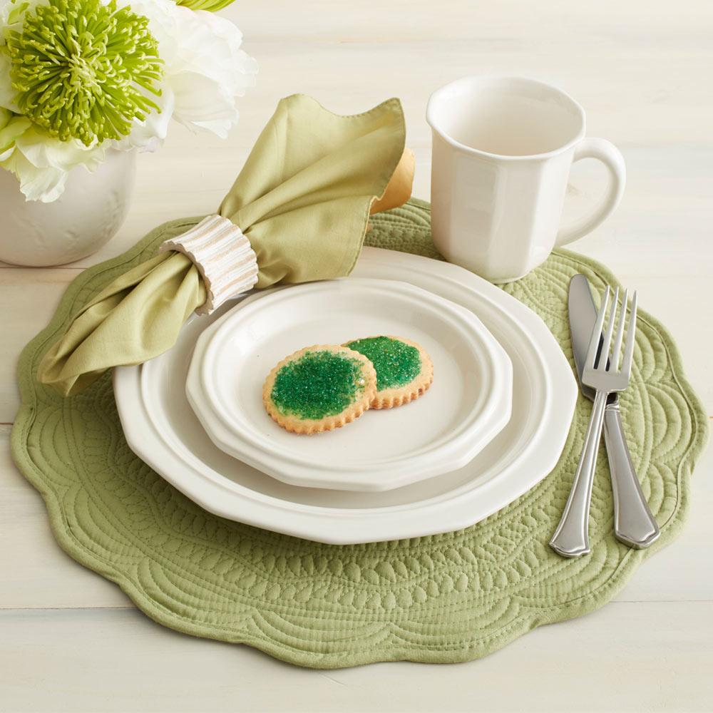Heritage white salad plate layered on a larger plate at a styled table setting with a green napkin and mug nearby.