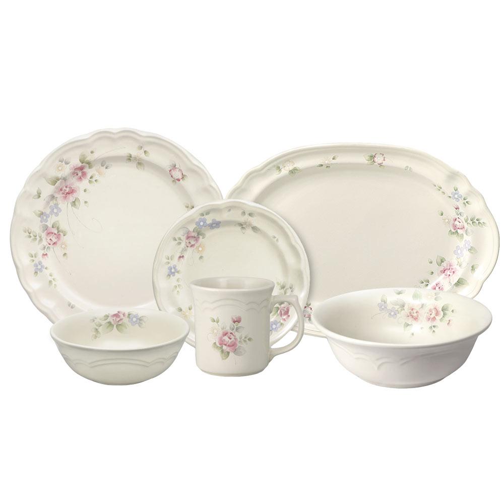Tea Rose dinnerware set with floral edge pattern shown with large and small plates bowls and a mug on display.