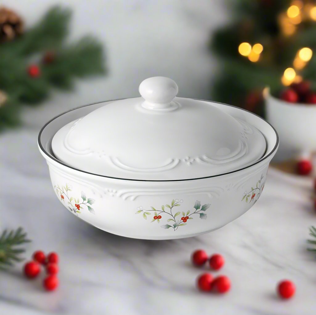 Winterberry round covered casserole in white porcelain with embossed scrollwork and holly motif, lid in place.