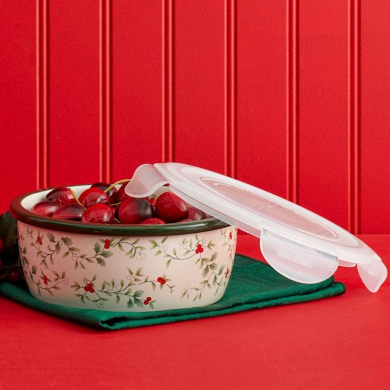 Winterberry storage bowl filled with cherries with a clear lid propped open beside it